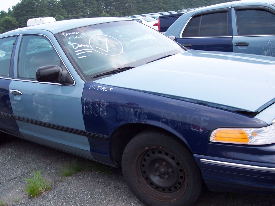 Two-tone blue police car, front quarter view, with '16 TIRES' and 'STATE POLICE' text visible
