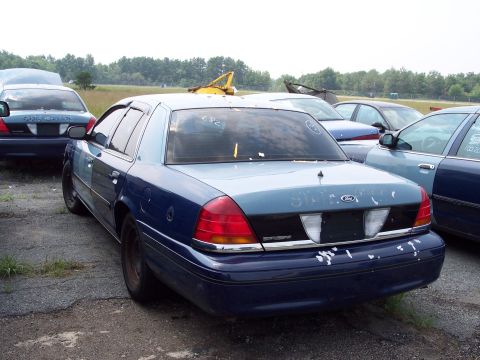 1991 Ford LTD Crown Victoria - A blue and light blue Ford Crown Victoria is seen from the rear in a lot with other vehicles.