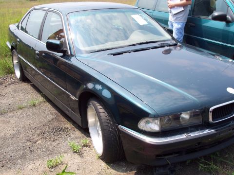 1991 Ford LTD Crown Victoria - A dark green sedan is parked outdoors, with another vehicle visible in the background.