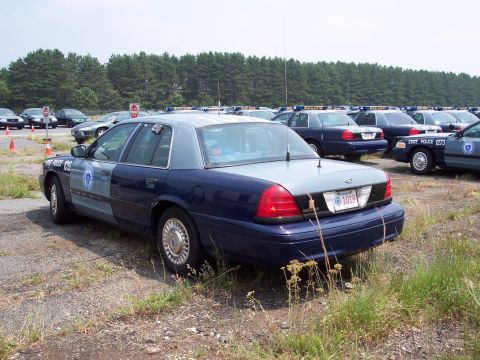1991 Ford LTD Crown Victoria - A fleet of police cars, including a 1991 Ford Crown Victoria LTD, parked in an outdoor lot.