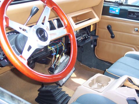 1991 Ford LTD Crown Victoria - The interior of a Jeep shows an aftermarket steering wheel and exposed wiring under the dashboard.