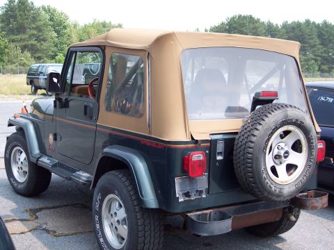1991 Ford LTD Crown Victoria - This Jeep Wrangler has 'WRANGLER' written on the side and a spare tire on the rear.