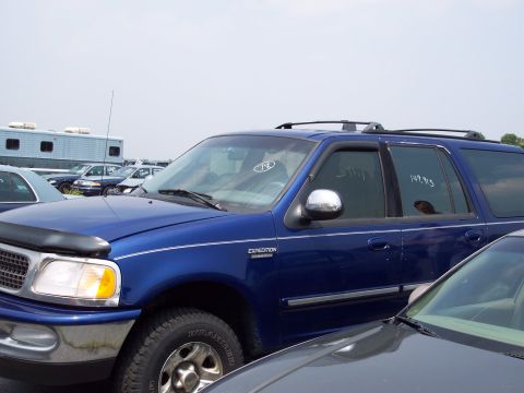 1991 Ford LTD Crown Victoria - A blue Ford Expedition SUV is parked in a lot with other vehicles.