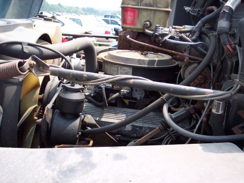 1991 Ford LTD Crown Victoria - View of a cluttered engine compartment with various hoses and wiring harnesses.