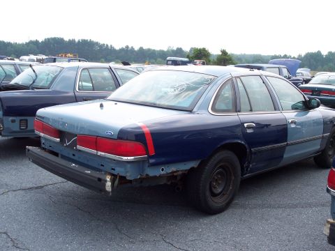 1991 Ford LTD Crown Victoria - A 1991 Ford Crown Victoria LTD in a junkyard shows off its two-tone paint job and missing rear bumper.