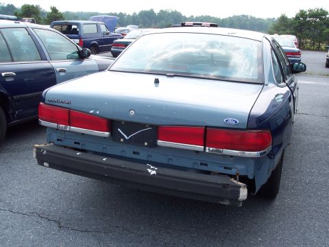 1991 Ford LTD Crown Victoria - Rear view of a 1991 Ford Crown Victoria with its bumper missing, revealing damage.