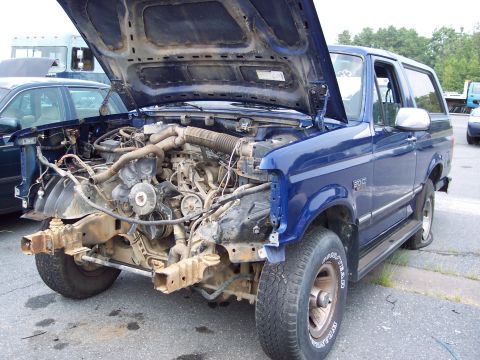 1991 Ford LTD Crown Victoria - This blue SUV, likely a 1992 model, has its hood open and front end dismantled, revealing the engine.