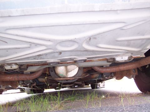 1991 Ford LTD Crown Victoria - A view of the undercarriage, focusing on the differential and rusted exhaust pipes.