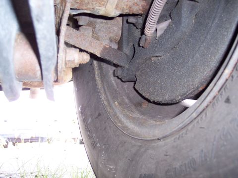 1991 Ford LTD Crown Victoria - Detail of a vehicle's brake drum and tire, showing signs of wear and rust.