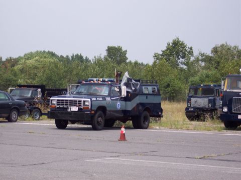1991 Ford LTD Crown Victoria - A Dodge Ram police truck, marked "STATE POLICE 2906", is parked alongside other vehicles.