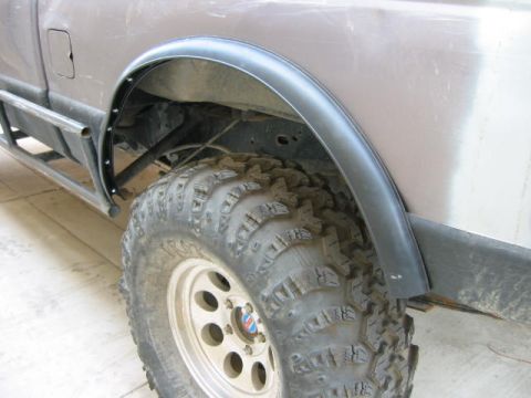1997 Ford Ranger - A close-up view of a vehicle's wheel well, a large off-road tire and a custom fender flare.