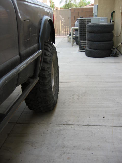1997 Ford Ranger - The side of a 1997 Ford Ranger is visible, focusing on the rear wheel and fender flare with a side step.