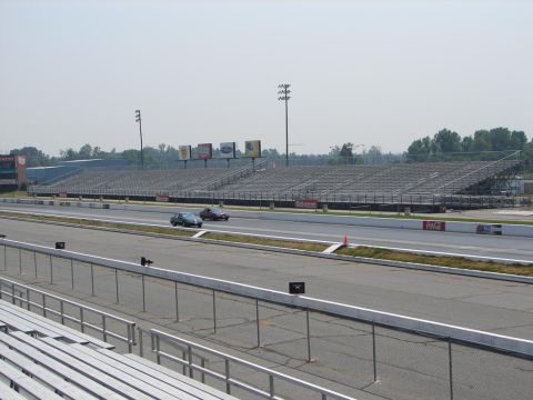 1992 Ford Taurus - A drag racing scene with two cars on the track and empty grandstands.