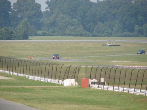 1992 Ford Taurus - Two cars are visible on a race track, one in the foreground and another further in the distance.