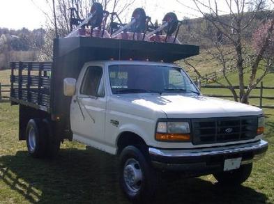 1996 Mercury Grand Marquis - 1995 Ford F-series flatbed truck loaded with equipment, parked outdoors on a grassy area.