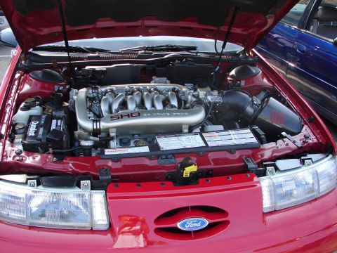 1992 Ford Taurus - The engine bay of a red 1992 Ford Taurus SHO is visible, with the V8 engine prominently displayed.