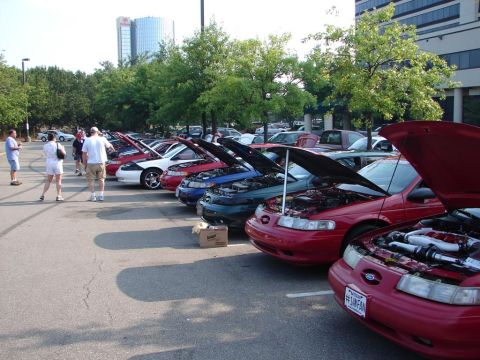 1992 Ford Taurus - A line of Ford Tauruses, most with hoods open, are parked at an outdoor event.