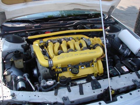 1992 Ford Taurus - Engine bay of a 1992 Ford Taurus, a yellow SHO 24 valve DOHC intake manifold.