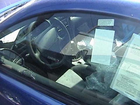 1989 Ford Mustang - The interior of a blue car is visible through the windshield, with papers and bubble wrap on the dashboard.
