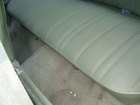 1975 Ford Torino - Interior view of a green bench seat and carpet, likely from a classic car.