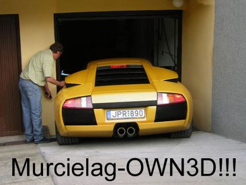 1994 Ford Probe - A man is backing a yellow Lamborghini Murcielago into a garage.