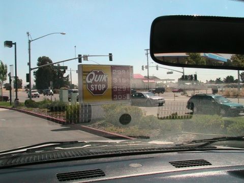 1971 Ford Bronco - View from inside a vehicle at a gas station, showing traffic and a Quik Stop sign.