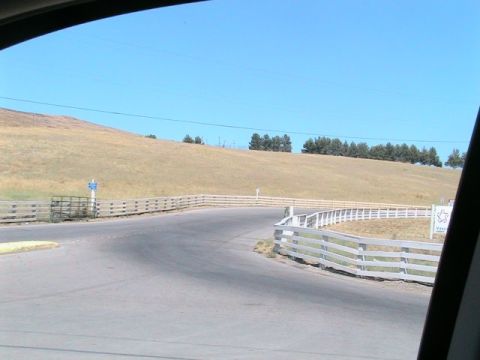 1971 Ford Bronco - A view of a road winding through a rural landscape with white fences lining the sides.