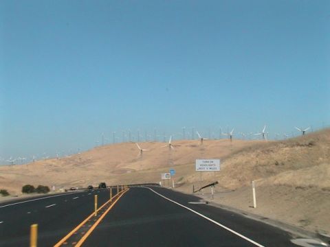 1971 Ford Bronco - A highway passes through a landscape dotted with numerous wind turbines under a clear blue sky.