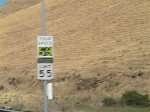 1971 Ford Bronco - A speed limit sign indicates 55 mph, while a digital display shows the vehicle's current speed at 59 mph.