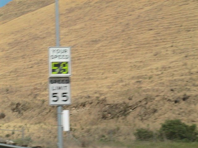 Speed limit sign shows 55, your speed is 59