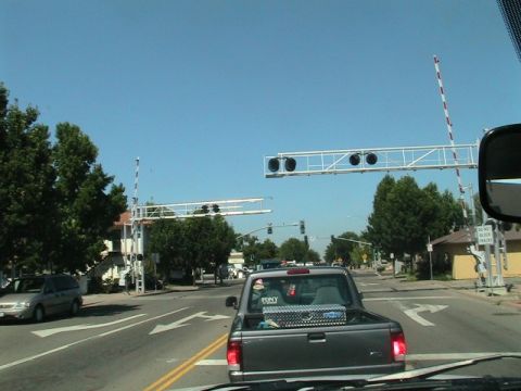 1971 Ford Bronco - A pickup truck waits at a railroad crossing as the gates are down.