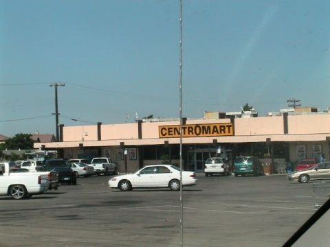 1971 Ford Bronco - A view of a parking lot outside a Centromart store on a clear day, with multiple vehicles present.