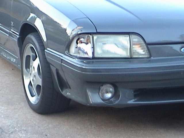 Gray 1989 Ford Mustang front corner with damaged headlight