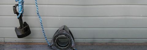 1993 Mazda RX-7 - A rotary engine rotor and a piston are displayed against a garage door, suggesting automotive parts.