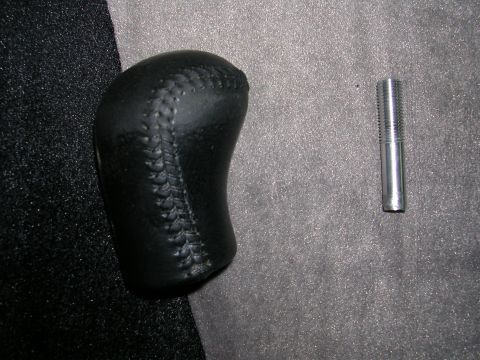 1996 Ford Probe - A black leather shift knob and a metal bolt are shown against a textured background.