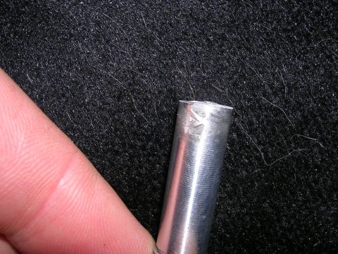 1996 Ford Probe - Metal rod with a stamped symbol, possibly a maker's mark, shown close-up.