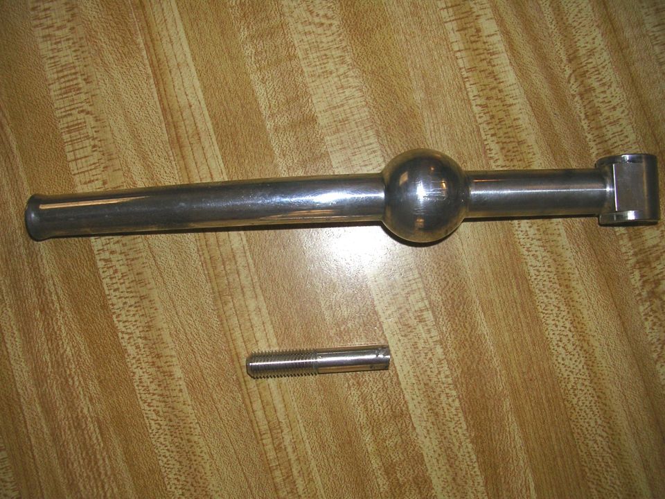 Gear shifter and a bolt on a wood-grain surface