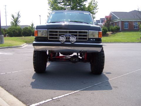 1990 Ford Bronco - Front view of a black 1990 Ford Bronco, equipped with Hella fog lights and a 4x4 badge.