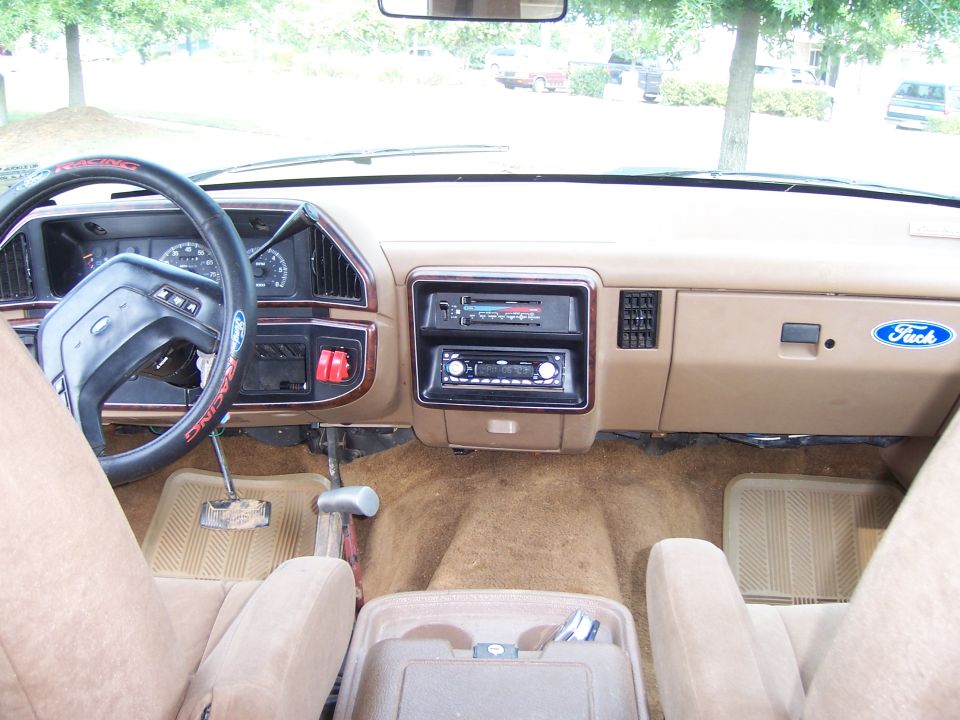 Tan Ford truck interior with Ford Racing steering wheel, stacked CD stereo and floor shifter