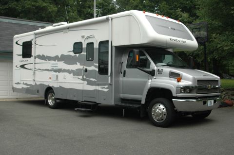 2005 Chevrolet C-6500/Kodiak - This RV motorhome, identified as a 2005 Chevrolet C-6500/Kodiak, is shown from a three-quarter front angle.