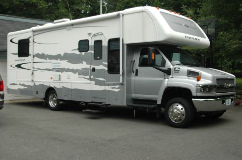 2005 Chevrolet C-6500/Kodiak - This 2005 Chevrolet C-6500/Kodiak RV motorhome features a silver exterior with gray cloud-like graphics and "ENDURA" branding.