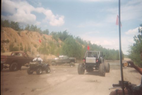 2004 Honda TRX 450 FM - A group of off-road vehicles and ATVs are gathered on a dirt path under a cloudy sky.