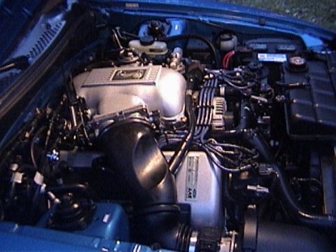 1989 Ford Mustang - Close-up view of a car's engine bay, showing various components and wiring.