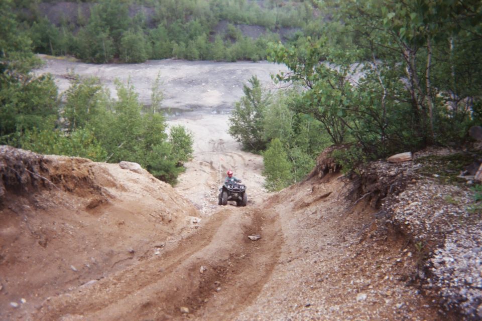 Four-wheeler descending a dirt path in a quarry