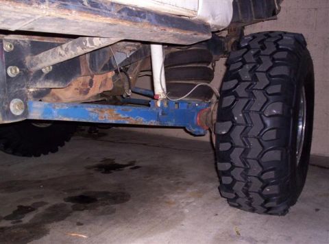 1995 Ford Bronco - The underside of a vehicle is shown, focusing on the suspension components and a large tire.