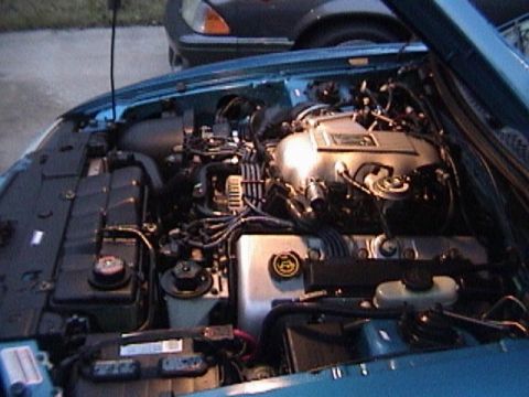 1989 Ford Mustang - Close-up view of the engine compartment, revealing the complex network of wires and mechanical parts.