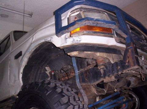 1995 Ford Bronco - Front view of a 1995 Ford Bronco showing its fender, wheel well, and a heavy-duty aftermarket bumper.