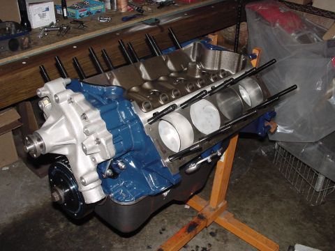 1979 Ford Bronco - A partially assembled engine block sits on a stand in a workshop.