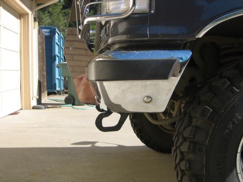 1989 Ford Bronco - Close-up of a truck's front bumper and tow hook, with a large tire in view.