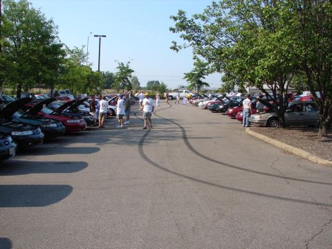 1992 Ford Taurus - Cars gathered in a parking lot, many with hoods open, suggesting a car show or meet-up.